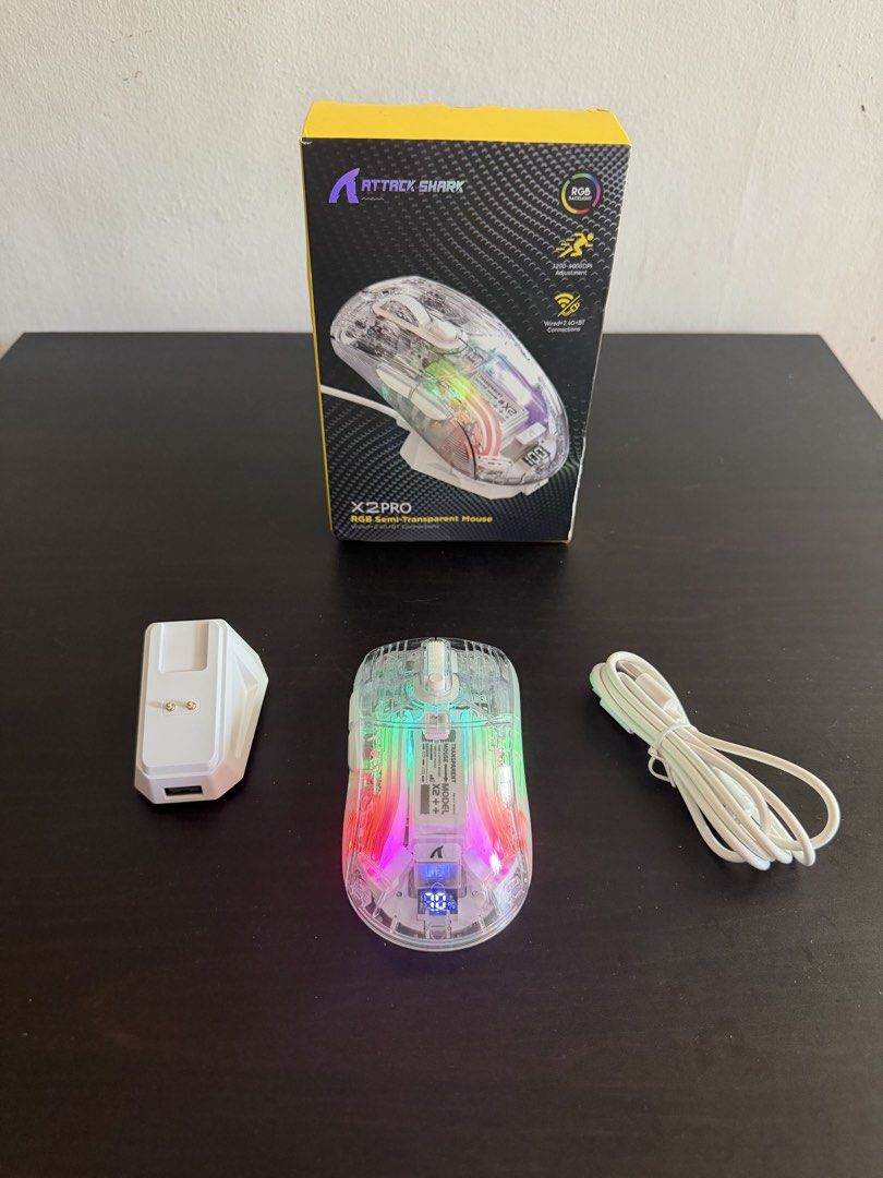 Attack Shark X2 PRO RGB Wireless Mouse (Category: Mouse & Mousepads) located in Las Pinas. Submitted by techietechtrove (Listing ID 1424574643, Image 2). Description: Attack Shark X2 PRO RGB Wireless Mouse The Attack Shark X2 Pro is a lightweight (approx. 109g-116g) transparent, tri-mode wireless gaming mouse featuring a PixArt PAW3212 sensor (up to 4000 DPI), 7 buttons, RGB lighting, and a magnetic charging base. It supports 2.4G, Bluetooth 5.0,