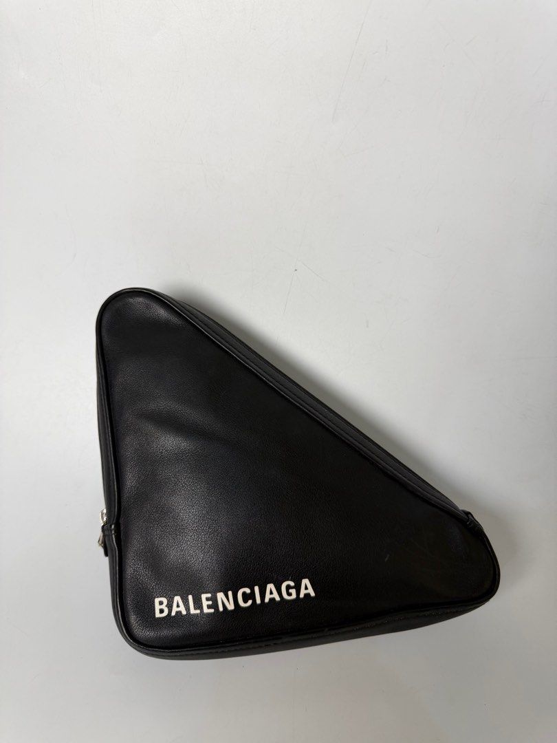 Balenciaga Triangle Clutch (Category: Luxury Bags & Wallets) located in Bayambang. Submitted by aevan143 (Listing ID 1424592808, Image 1). Description: - Balenciaga Triangle Clutch - Black exterior with white Balenciaga logo - Red interior - Interior features Balenciaga logo and serial number - Zip closure - Made in Italy.