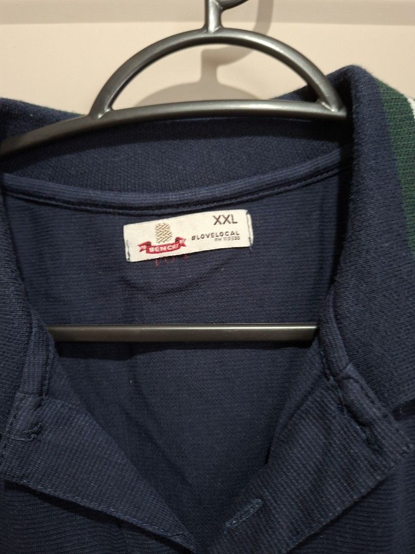Bench Polo Shirt XXL (Category: Tshirts & Polo Shirts ) located in Manila. Submitted by shelly2004 (Listing ID 1424608793, Image 2). Description: - Navy blue Bench polo shirt - Size: XXL - Green stripe details on collar and sides - Collared neckline with a three-button placket - Short sleeves - Relaxed fit - Bench logo visible.