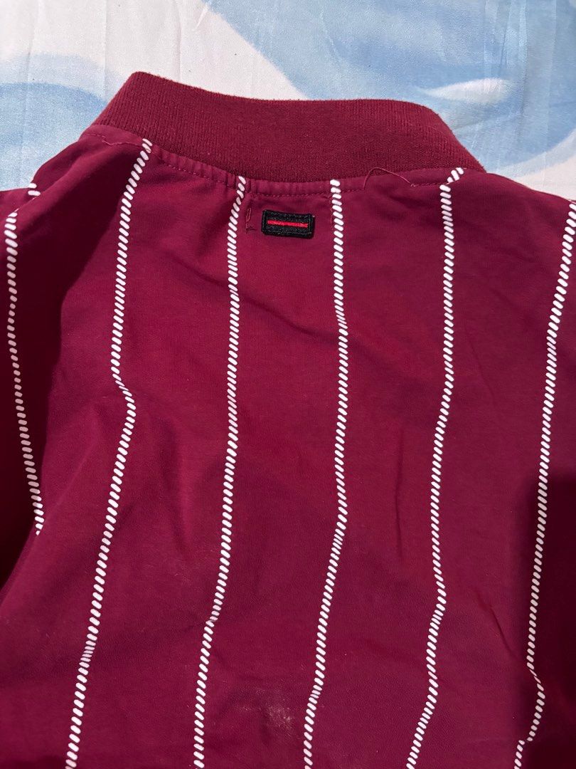 Fubu NY Varsity Jacket (Category: Others Tops) located in Orani. Submitted by cathsclothing (Listing ID 1424597856, Image 3). Description: - Fubu varsity jacket - Color: Maroon and white - Design: Striped body, white sleeves - Features: "NY" logo, Fubu embroidery - Closure: Button-up - Details: Ribbed collar and cuffs - Size: Medium.