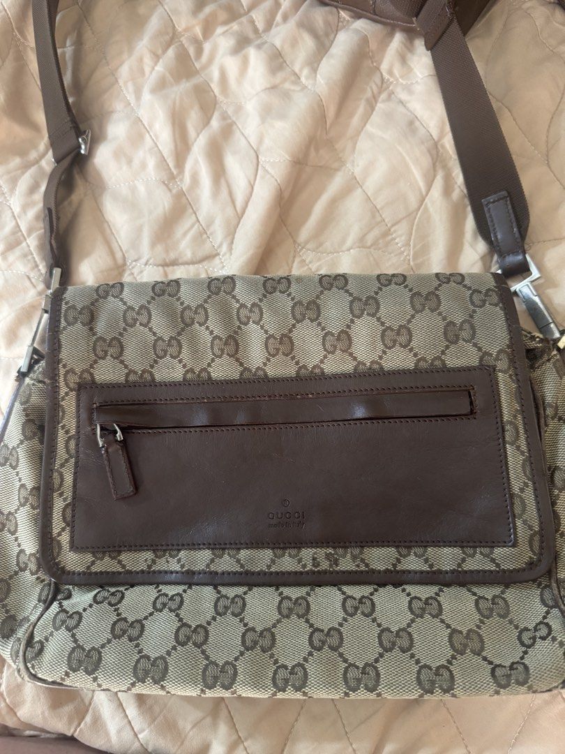 Gucci GG Canvas Shoulder Bag (Category: Luxury Bags & Wallets) located in Mandaluyong City. Submitted by myanikaaaa (Listing ID 1424606203, Image 3). Description: - Authentic Gucci shoulder bag - Iconic GG canvas design - Brown leather front pocket and trim - Adjustable shoulder strap - Spacious interior with zippered pocket - Made in Italy - Minor wear on corners and edges.