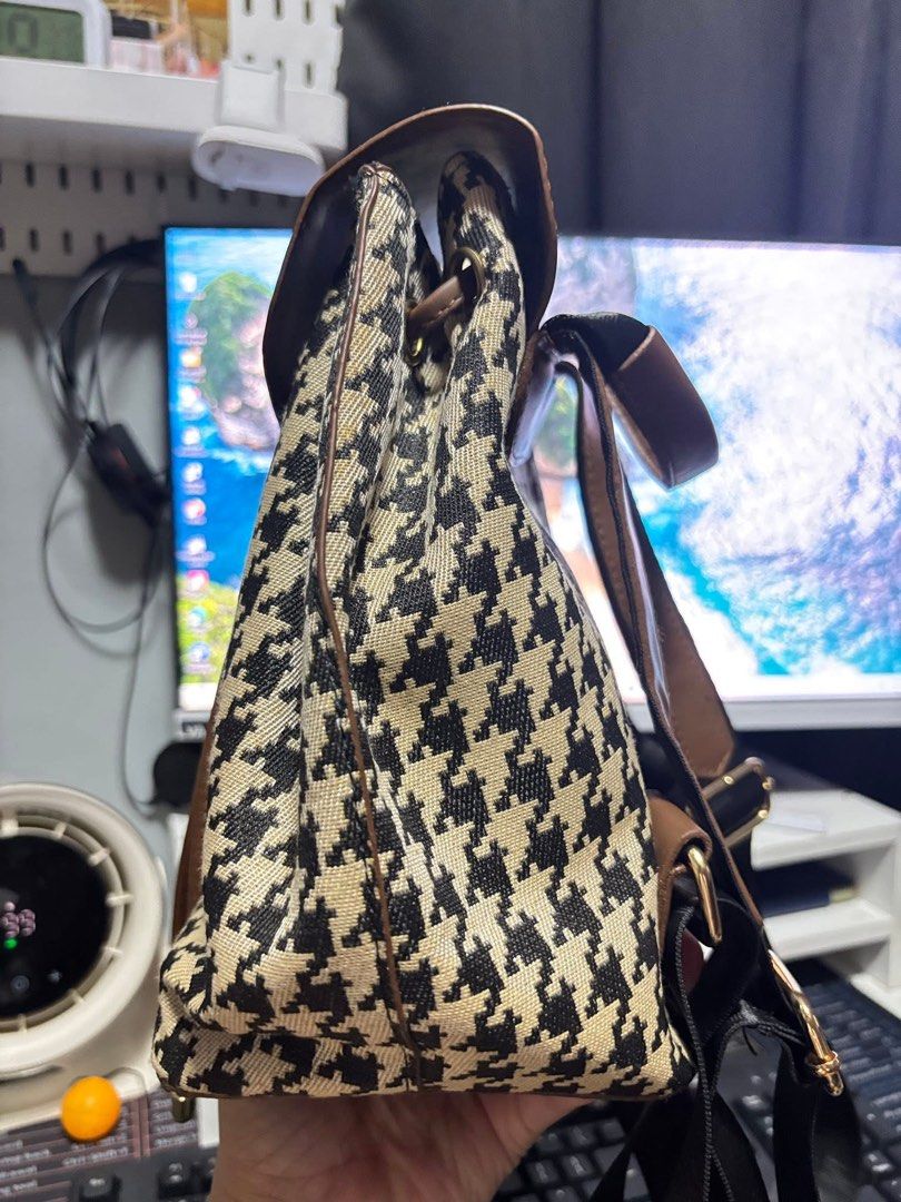 Houndstooth Pattern Backpack (Category: Backpacks) located in Manila. Submitted by dnash29 (Listing ID 1424614626, Image 3). Description: - Houndstooth pattern backpack with brown accents - Flap closure with buckle and drawstring - Adjustable straps - Small front pocket - Includes a cute smiley face charm - Perfect for everyday use.