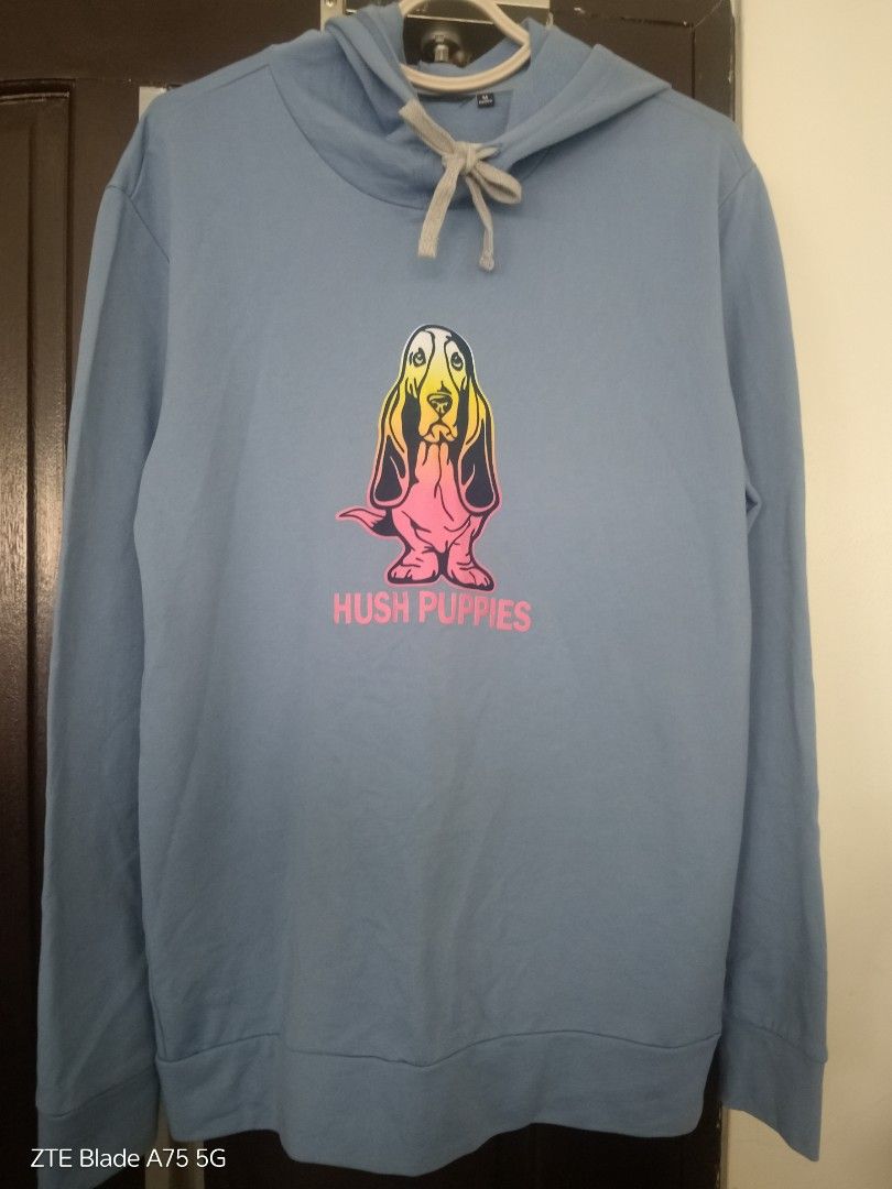 Hush Puppies Hoodie (Category: Coats, Jackets and Outerwear) located in Manila. Submitted by berrymecreates (Listing ID 1424587465, Image 2). Description: Hush Puppies hoodie features the iconic basset hound logo. It has a drawstring hood and long sleeves. The hoodie is a light blue color. The logo is in the center of the chest. It is a comfortable and stylish piece of clothing..