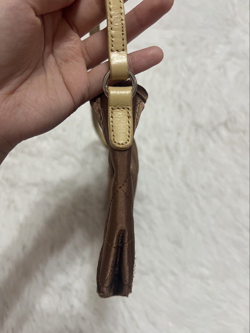 Jacob Brown Quilted Baguette Bag (Category: Luxury Bags & Wallets) located in Silang. Submitted by _superjea (Listing ID 1424624789, Image 3). Description: - Brown quilted bag - Decorative flower embellishment - Beige handle - Silver zipper - Pink interior lining - Shoulder bag or small handbag - Satin-like texture.