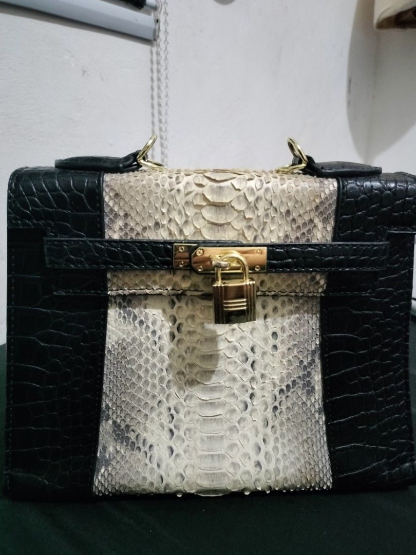 Kelly Snakeskin Sling bag (Category: Luxury Bags & Wallets) located in General Trias. Submitted by sensei_annyana (Listing ID 1424645260, Image 3). Description: - Black and white snakeskin handbag - Structured design - With Sling - Secure lock closure - Crocodile-like texture on black sections.