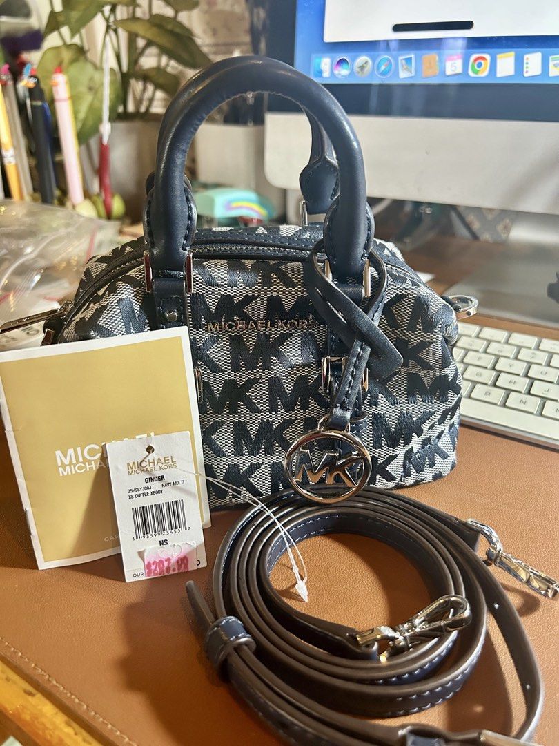 Michael Kors ginger xs mini duffle bag (Category: Luxury Bags & Wallets) located in Quezon City. Submitted by asiaco (Listing ID 1419823581, Image 1). Description: For those who are keen on tiny things like me, this is an Authentic Michael Kors ginger xs mini duffle bag. Features a navy blue and gray MK logo pattern. Includes a detachable shoulder strap and a top handle. The bag has silver hardware and an MK charm. The original price tag is inclu
