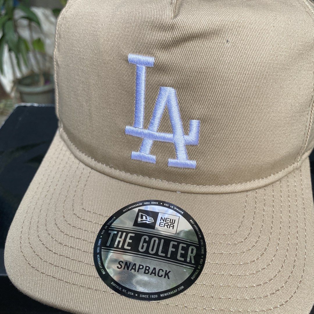 New Era LA Dodgers The Golfer Snapback Cap (Category: Caps & Hats) located in Manila. Submitted by jpdavidso (Listing ID 1424546430, Image 3). Description: - New Era LA Dodgers snapback cap - 'The Golfer' style - Tan color - White embroidery - White underbrim - Black interior - One size fits most.
