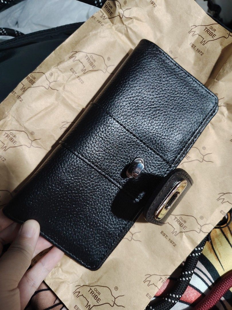 Our Tribe Black Leather Wallet (Category: Wallets & Card holders) located in Valenzuela. Submitted by ryu12 (Listing ID 1424687295, Image 1). Description: Black leather wallet from Our Tribe. Features multiple card slots, a clear ID window, and a zippered compartment. The wallet has a snap closure and a textured leather exterior. The interior also has the Our Tribe logo embossed. Original price 2875.00 Almost new. No any issues. Never been used. 