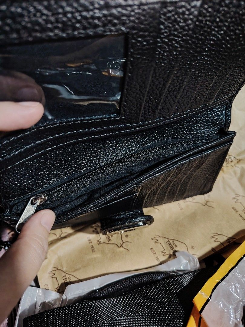 Our Tribe Black Leather Wallet (Category: Wallets & Card holders) located in Valenzuela. Submitted by ryu12 (Listing ID 1424687295, Image 3). Description: Black leather wallet from Our Tribe. Features multiple card slots, a clear ID window, and a zippered compartment. The wallet has a snap closure and a textured leather exterior. The interior also has the Our Tribe logo embossed. Original price 2875.00 Almost new. No any issues. Never been used. 