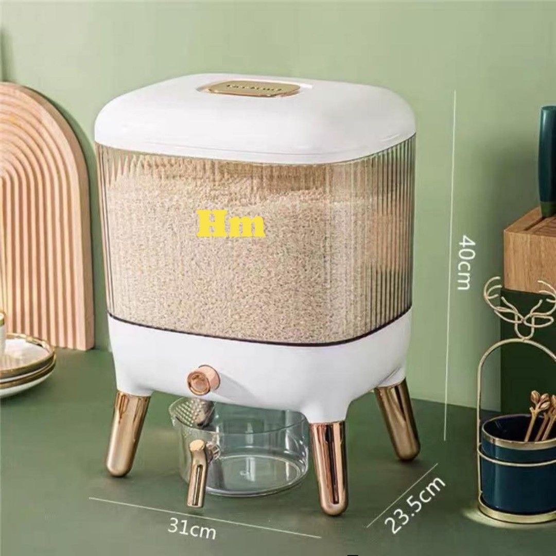 RICE DISPENSER (Category: Food Organization & Storage) located in Manila. Submitted by haideshop (Listing ID 1424612892, Image 2). Description: Stylish rice dispenser with a clear, ribbed container. Features a gold-accented base and legs. Includes a measuring cup for easy portioning. Dimensions are approximately 31cm x 23.5cm x 40cm. The dispenser has a dispensing valve for convenient access to rice. The design is modern and suitable for kitchen 