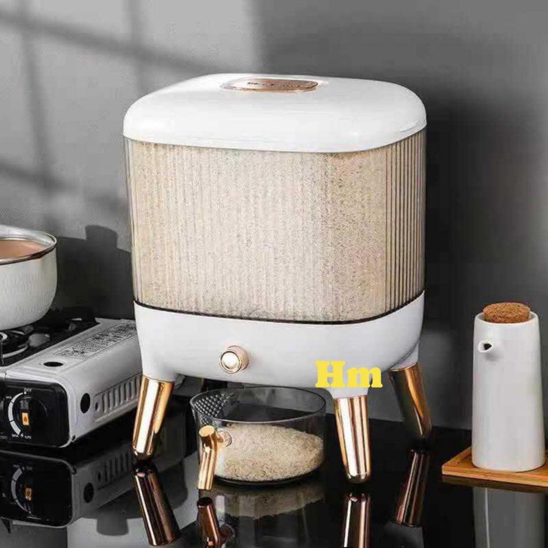 RICE DISPENSER (Category: Food Organization & Storage) located in Manila. Submitted by haideshop (Listing ID 1424612892, Image 1). Description: Stylish rice dispenser with a clear, ribbed container. Features a gold-accented base and legs. Includes a measuring cup for easy portioning. Dimensions are approximately 31cm x 23.5cm x 40cm. The dispenser has a dispensing valve for convenient access to rice. The design is modern and suitable for kitchen 