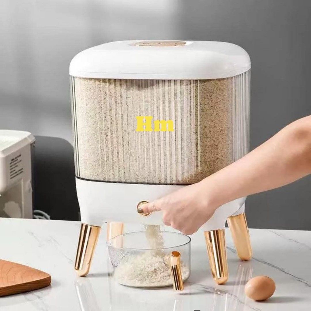 Rice Dispenser with Measuring Cup (Category: Food Organization & Storage) located in Manila. Submitted by jelai.cybyb (Listing ID 1424611406, Image 2). Description: Stylish rice dispenser with a clear container and a convenient measuring cup. Features a modern design with gold-colored accents on the legs. It has a capacity to store a good amount of rice, keeping it fresh and easily accessible. The dispenser has a tap for easy dispensing. Dimensio