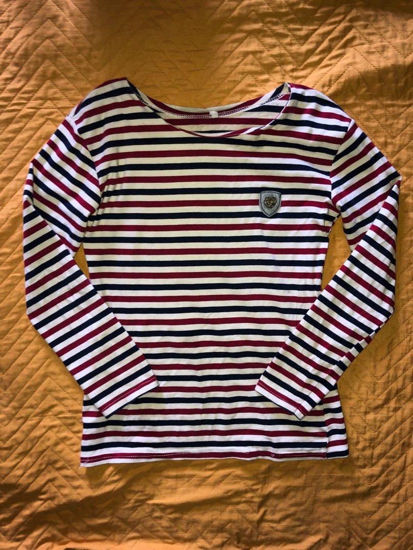 Striped Long Sleeve Shirt (Category: Longsleeves) located in Alcala. Submitted by grisch (Listing ID 1424527511, Image 1). Description: - Striped long sleeve shirt - Brand: Jeans - Size: XS-S - Color: Red, navy, and white stripes - Features a small emblem detail - Versatile and stylish has a super minor issue (check last image).