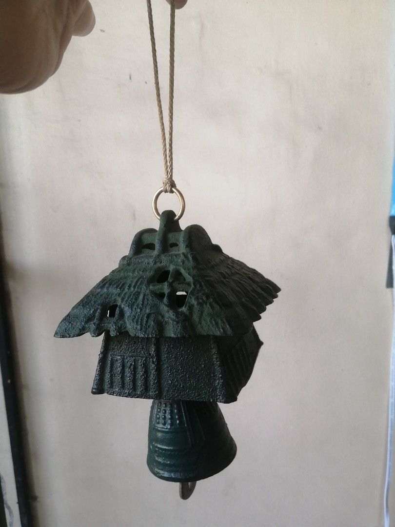 Vintage Japanese Cast Iron Wind Chime (Category: Other Home Decor) located in Liloan. Submitted by aidolcapz88 (Listing ID 1424604146, Image 2). Description: Vintage wind chime features a unique Japanese design. It has a tiered structure with a bell at the bottom. The chime is suspended by a rope and a metal ring. The color is a dark green..