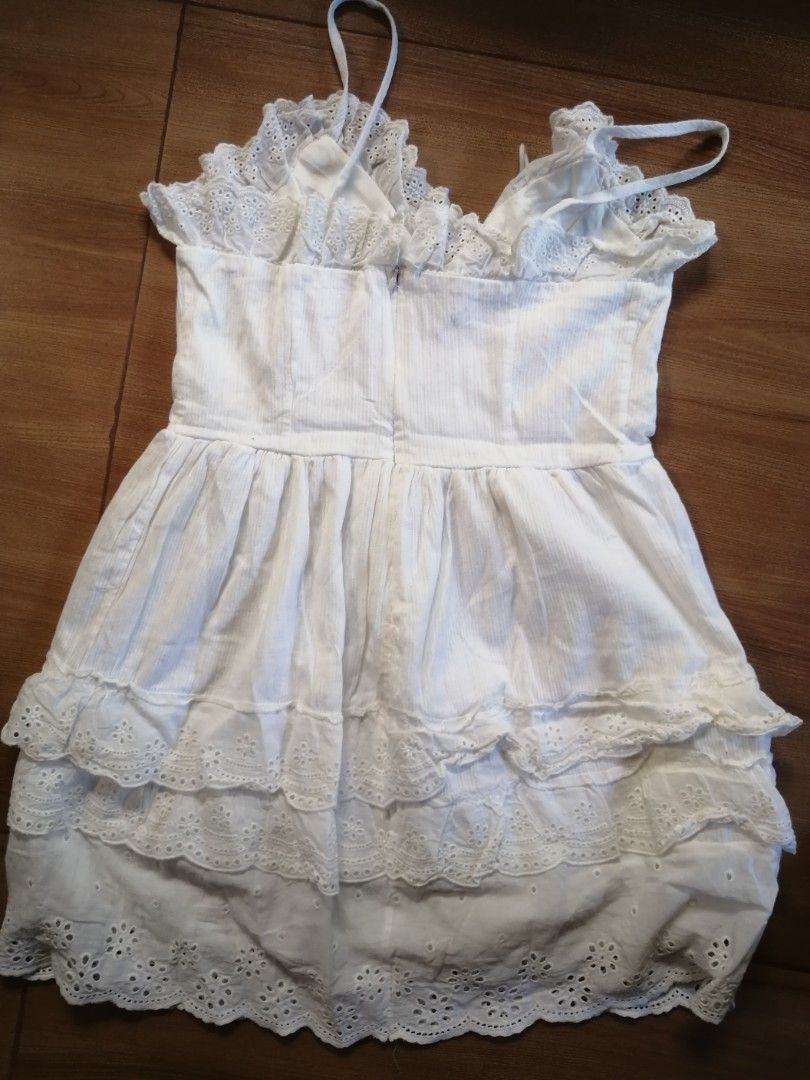 White Lace-Up Dress (Category: Dresses) located in Taytay. Submitted by 7_OneThree (Listing ID 1424576214, Image 2). Description: White dress with lace-up detail and spaghetti straps. Features a tiered design with lace trim. The dress has a V-neckline and a fitted waist. Length - 30 inches. waist - 28 inches The back of the dress has a zipper..