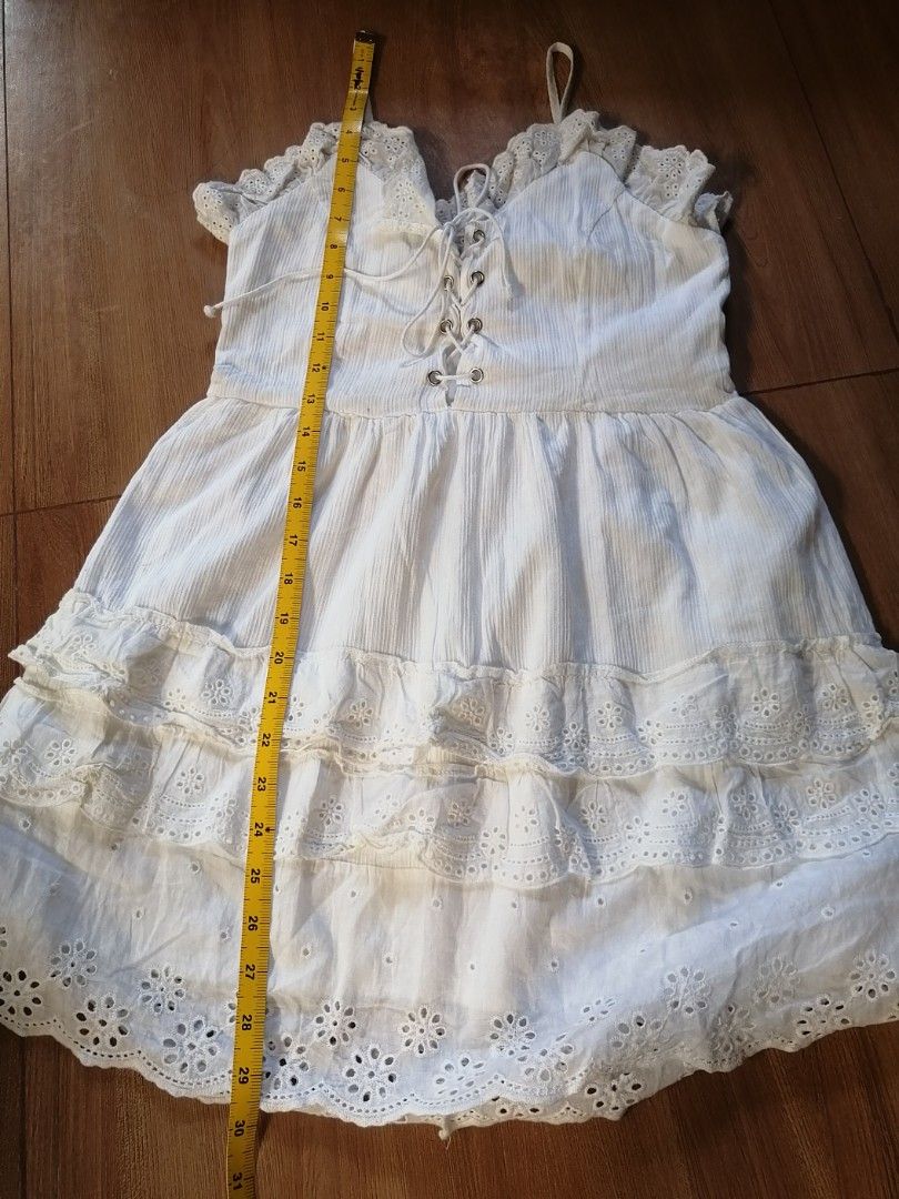White Lace-Up Dress (Category: Dresses) located in Taytay. Submitted by 7_OneThree (Listing ID 1424576214, Image 3). Description: White dress with lace-up detail and spaghetti straps. Features a tiered design with lace trim. The dress has a V-neckline and a fitted waist. Length - 30 inches. waist - 28 inches The back of the dress has a zipper..