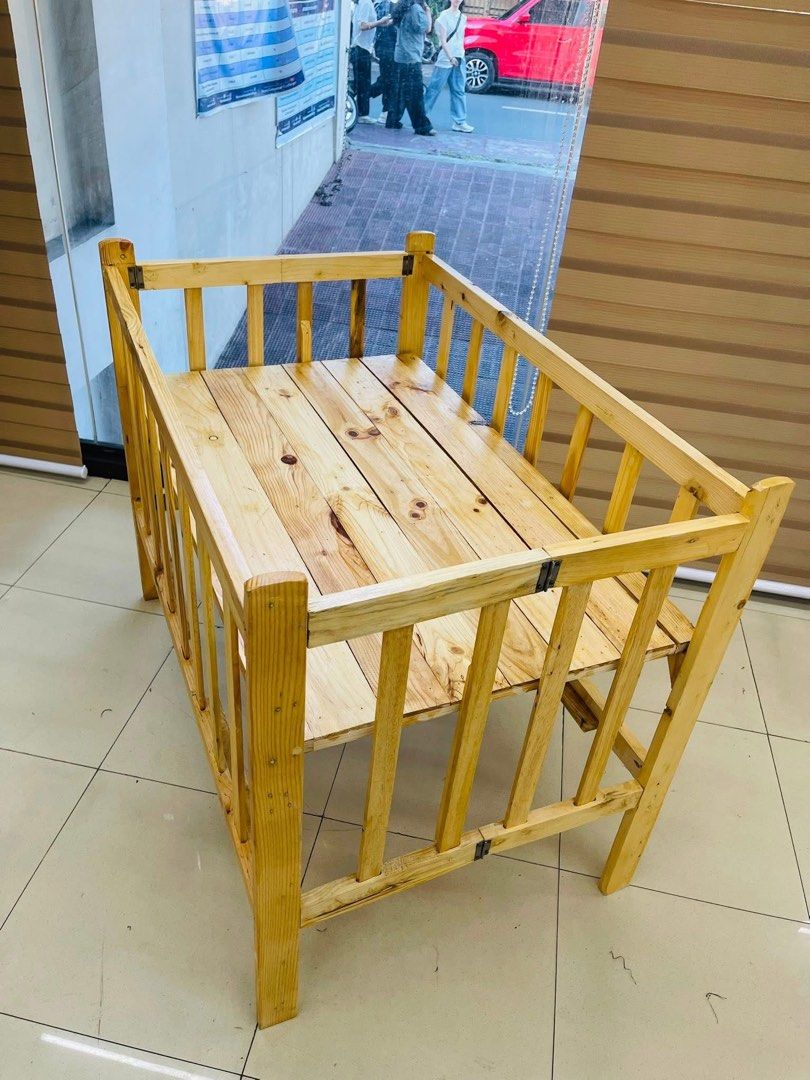 Wooden Baby Crib with Bedding (Category: Cots & Cribs) located in Las Pinas. Submitted by shytorres (Listing ID 1424534047, Image 2). Description: Handcrafted wooden baby crib. Includes a wooden frame with a slatted base and sides. Comes with a fitted sheet. Several bedding designs are available, including Cinnamoroll, dinosaurs, and hearts. The crib is designed for a baby's comfort and safety. Perfect for your little one!.