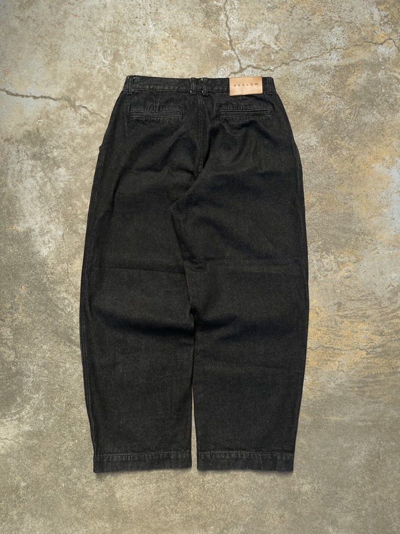 Y2k Beslow Black Raw Pleated Jeans (Category: Jeans) located in Bulacan. Submitted by archivesgallery_ (Listing ID 1424601273, Image 2). Description: Black Beslow jeans. Features a relaxed fit with a pleated front design. Includes two front pockets and two back pockets. The Beslow brand tag is visible at the back. The jeans have a straight leg cut. -Measurements Waist: 30-31 Rise: 11.5 Length: 38 Leghole: 9 Thigh: 13 .