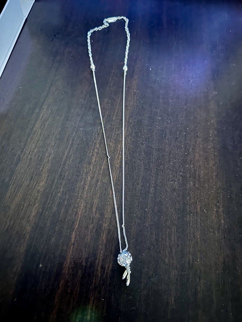 Charles & Keith Silver Necklace (Category: Necklaces) located in Quezon City. Submitted by spatio (Listing ID 1424710002, Image 2). Description: Elegant Charles & Keith necklace. Features a silver chain with a decorative pendant. The pendant has a spherical design with crystal embellishments and two dangling silver charms. Comes with its original box..