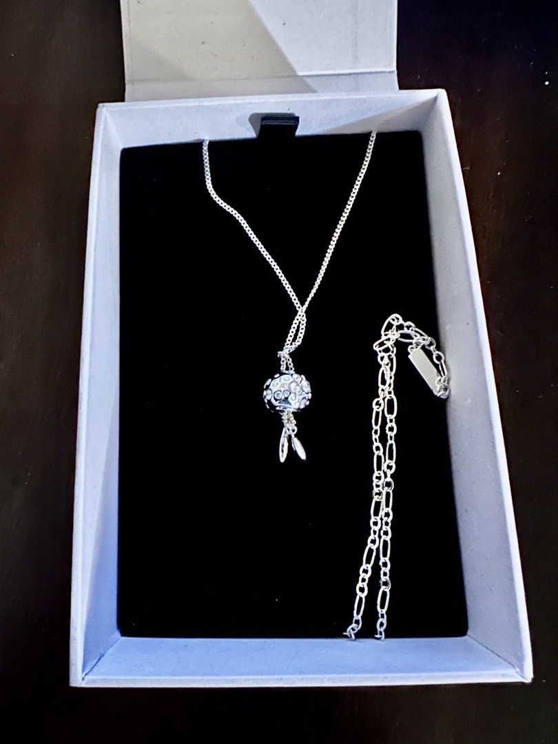 Charles & Keith Silver Necklace (Category: Necklaces) located in Quezon City. Submitted by spatio (Listing ID 1424710002, Image 1). Description: Elegant Charles & Keith necklace. Features a silver chain with a decorative pendant. The pendant has a spherical design with crystal embellishments and two dangling silver charms. Comes with its original box..