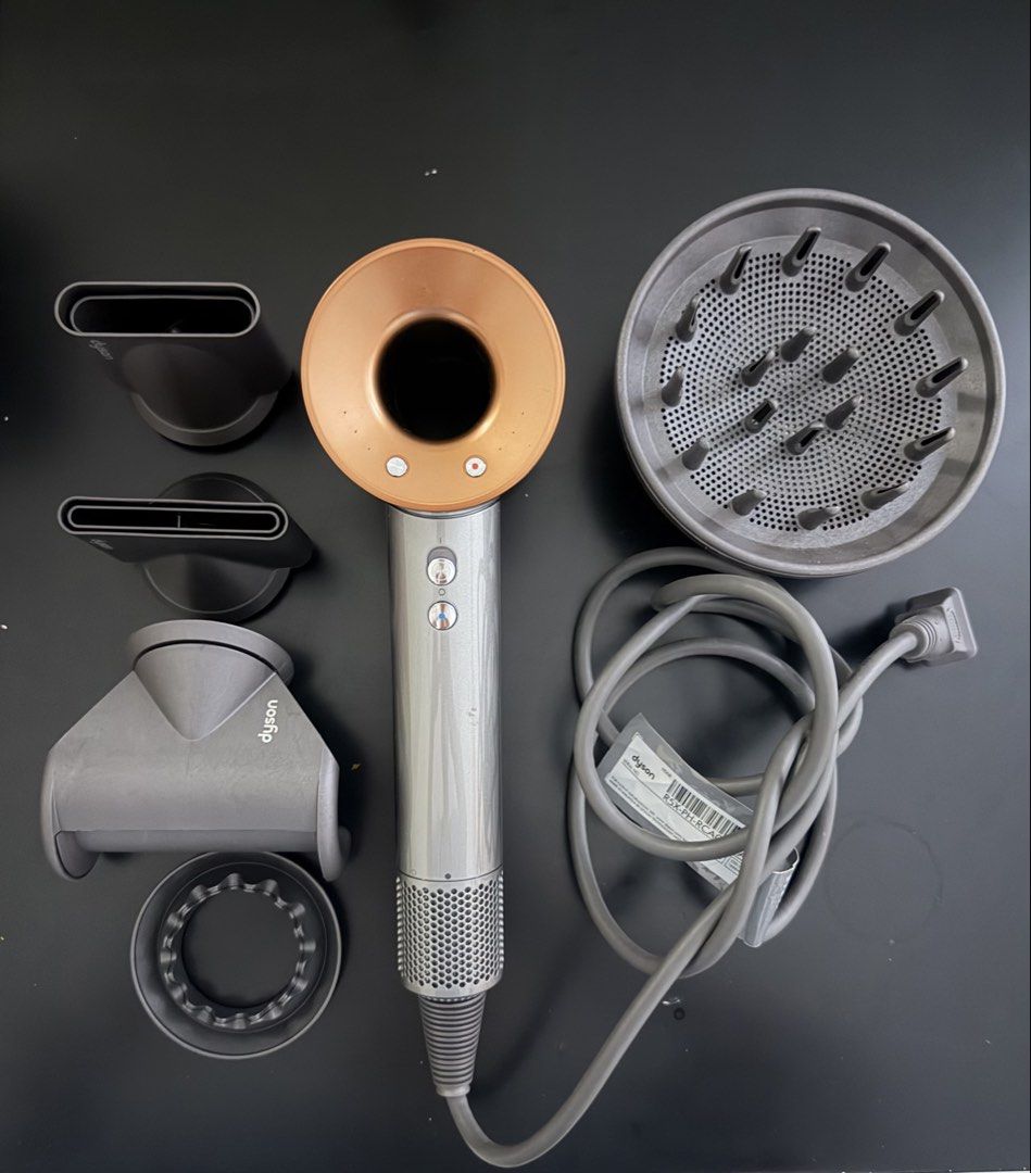 Dyson Supersonic Hair Dryer (Category: Hair) located in Manila. Submitted by irajor (Listing ID 1424842143, Image 1). Description: - Dyson Supersonic hair dryer - Silver and copper color - Includes all original attachments: - Diffuser - Multiple nozzles - Power cord included.