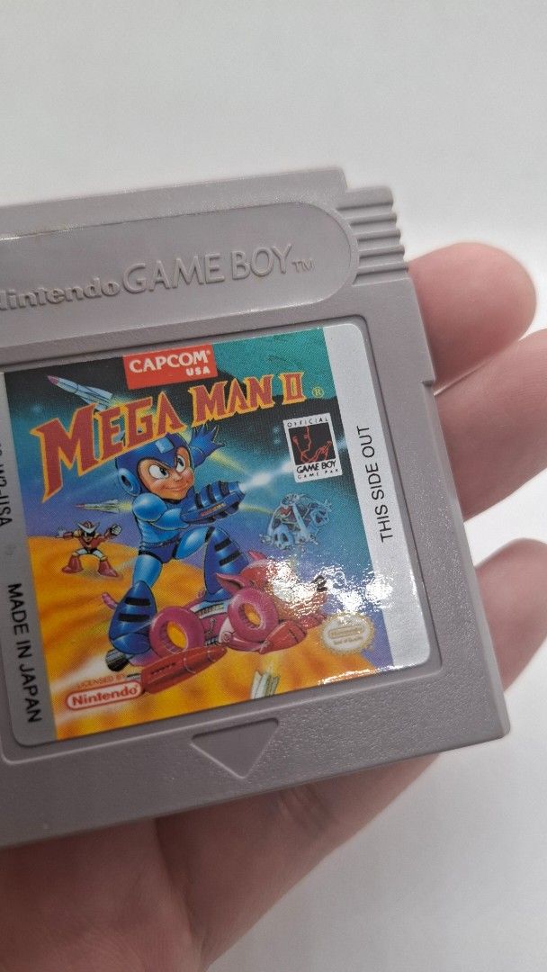 Gameboy Mega-Man 2 with cartridge case protector (Category: Nintendo) located in San Juan City. Submitted by ricsgaragesale (Listing ID 1424776857, Image 3). Description: Mega-Man 2 Gameboy. Price: 2,500 PHP - Authentic. - Tested and working. - Pristine label condition and the cartridge case is in good condition, kindly check the pictures. - With 1 free authentic cartridge case protector. Issue: There's a slightly yellowish at the back of the car