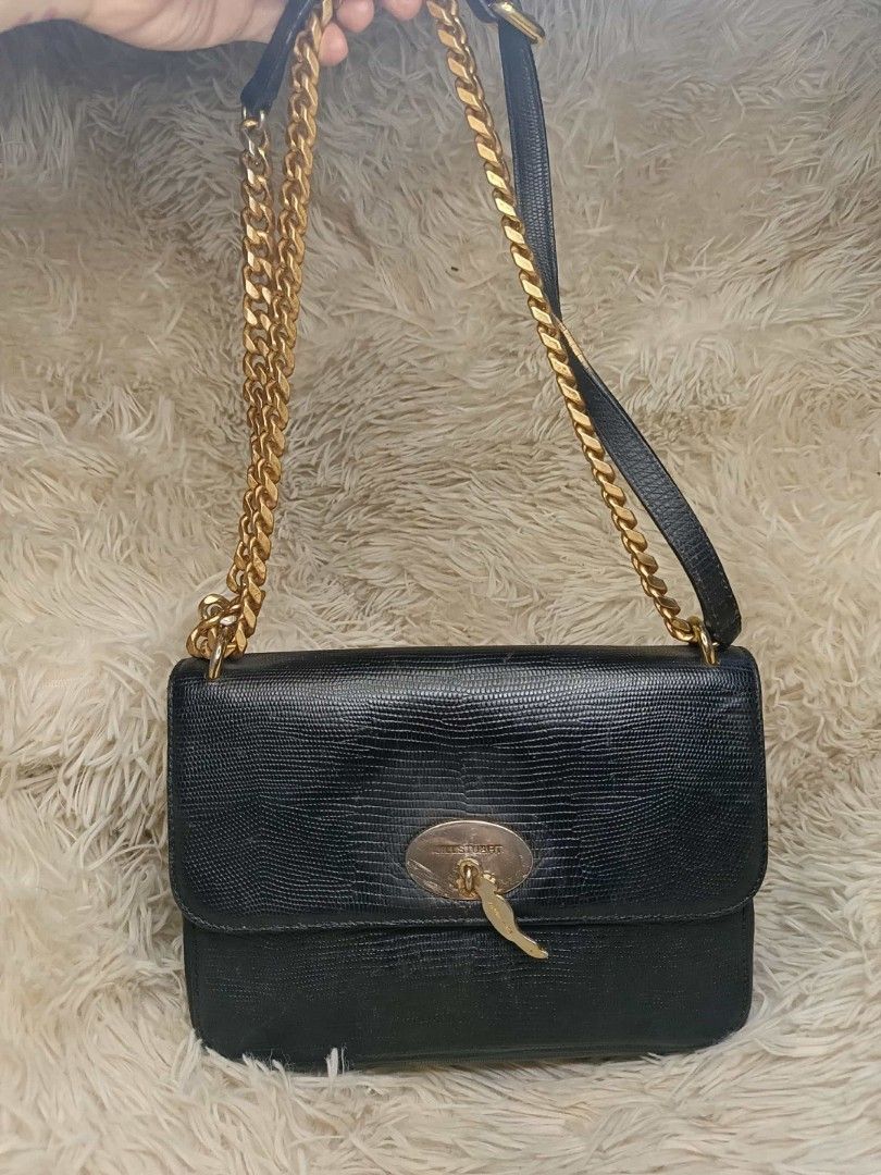 Jill Stuart Black Shoulder Bag with Gold Chain (Category: Shoulder Bags) located in Manila. Submitted by mariecunan80818 (Listing ID 1424708748, Image 1). Description: Black shoulder bag by Jill Stuart. Features a gold chain strap and a flap closure with a decorative charm. The interior includes multiple compartments, including a zippered pocket. The bag has a textured finish and a gold buckle on the adjustable strap. The interior is lined with b