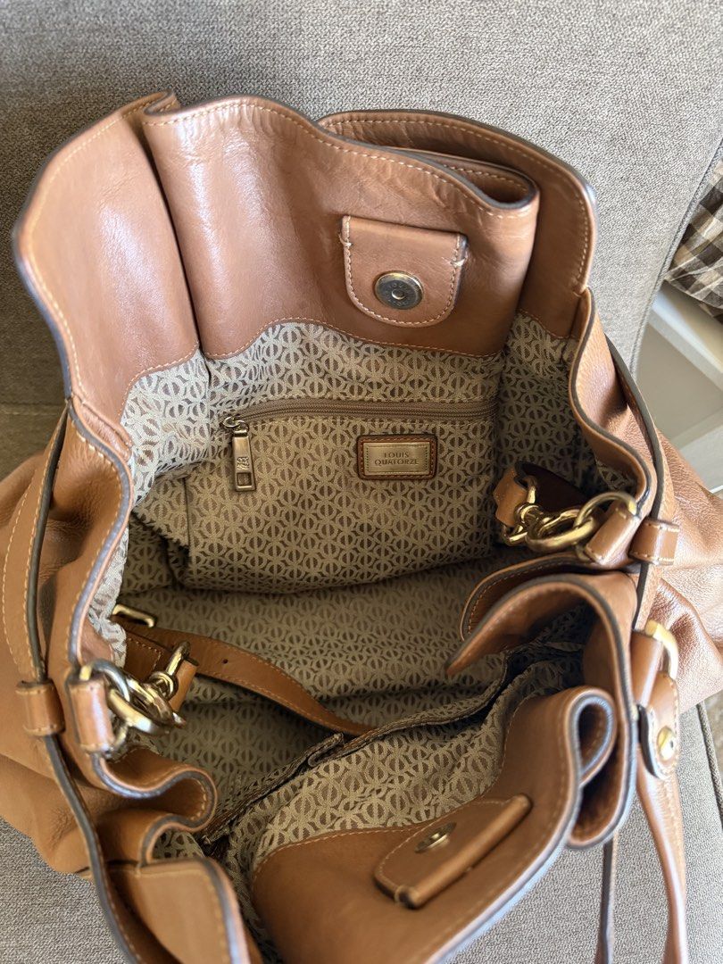 Louis Quatorze Brown Leather Handbag (Category: Luxury Bags & Wallets) located in Taguig. Submitted by gocupnoodles (Listing ID 1424716846, Image 2). Description: - Authentic Louis Quatorze handbag - Brown leather -With belt buckle detail for style - Top handle and detachable shoulder strap - Patterned interior lining - Interior zippered pocket - Secure buckle closure - Elegant gold-tone hardware - Louis Quatorze branding visible.