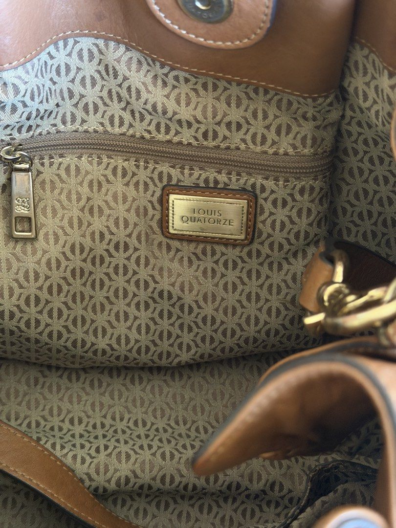 Louis Quatorze Brown Leather Handbag (Category: Luxury Bags & Wallets) located in Taguig. Submitted by gocupnoodles (Listing ID 1424716846, Image 3). Description: - Authentic Louis Quatorze handbag - Brown leather -With belt buckle detail for style - Top handle and detachable shoulder strap - Patterned interior lining - Interior zippered pocket - Secure buckle closure - Elegant gold-tone hardware - Louis Quatorze branding visible.