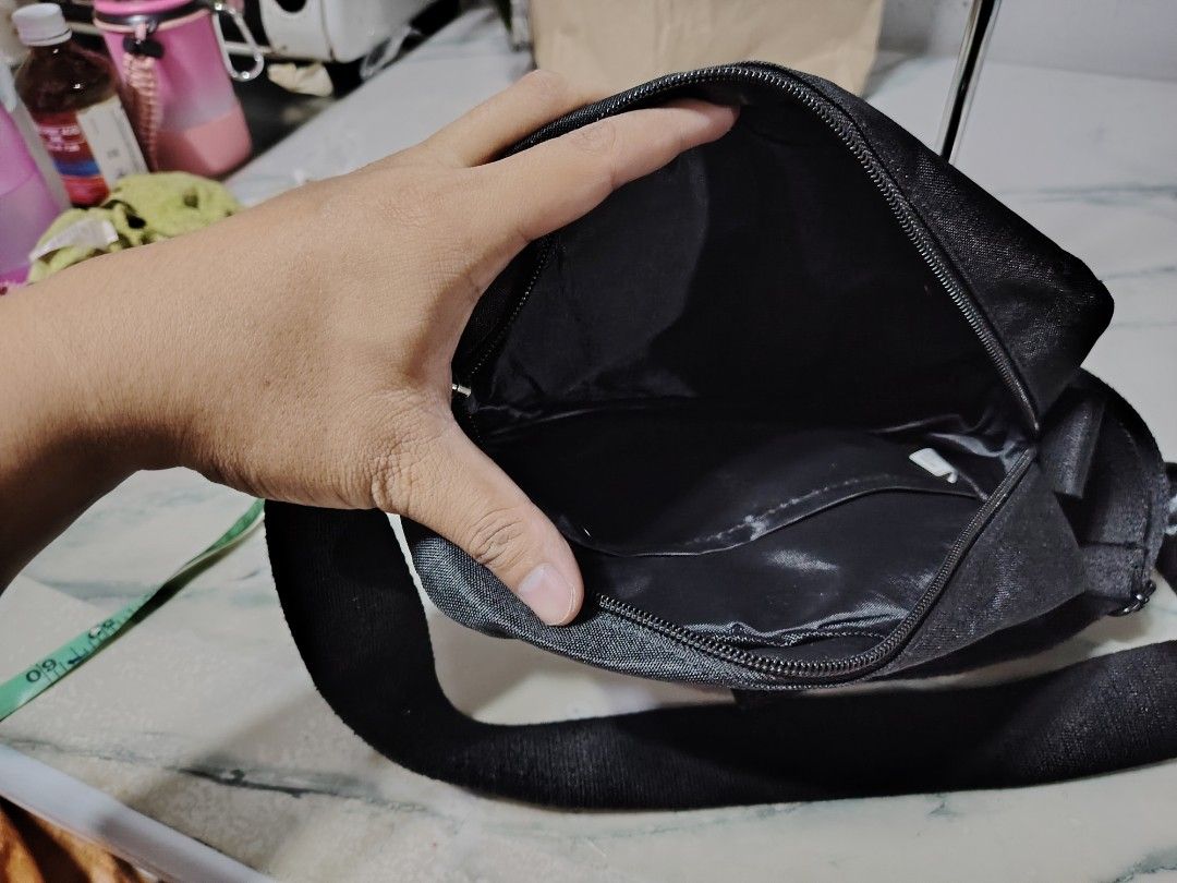 Mens sling bag black (Category: Sling Bags) located in Manila. Submitted by drxx.drip_19 (Listing ID 1424818480, Image 2). Description: - Black men's sling bag - Stylish and simple design - Features a front pocket - Adjustable strap for comfort - Ideal for everyday use.