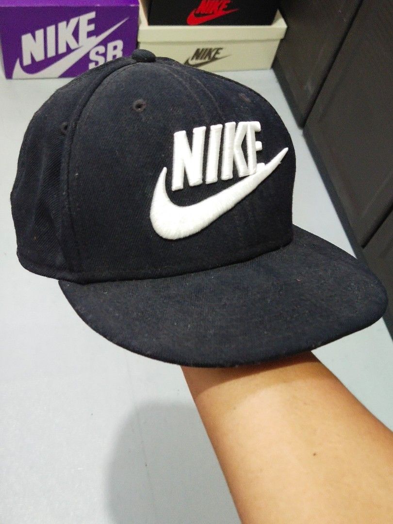 Nike Cap (Category: Caps & Hats) located in Manila. Submitted by djs777 (Listing ID 1424791806, Image 1). Description: Black Nike cap with a white Nike logo on the front. The cap has a flat brim and a structured crown. The interior features Nike branding and size information. It has a classic, sporty design..