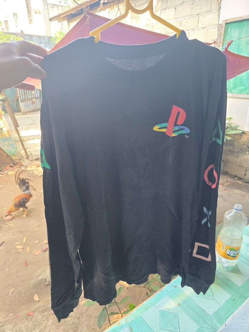 PlayStation Long Sleeve Shirt (Category: Tshirts & Polo Shirts ) located in Puerto Princesa. Submitted by palawan_vintage (Listing ID 1424882639, Image 3). Description: Black long sleeve shirt featuring the PlayStation logo on the front and controller button symbols on the sleeves. The shirt has a crew neck. The tag is visible in the image..