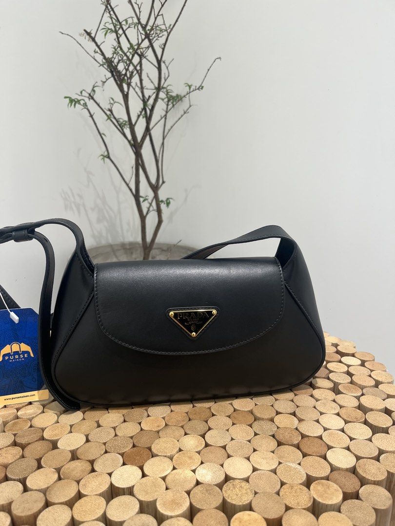 Prada Cleo Logo Plaque Shoulder Bag (Category: Luxury Bags & Wallets) located in Taguig. Submitted by raraofpursemaison (Listing ID 1424752288, Image 1). Description: Condition: Mint (9.3/10) Exterior: Mild marks on the corner, wrinkles on strap and minor press marks. Interior: Mild marks on the leather and mild signs of usage. Hardware: Hairline scratches. Inclusions: Dust Bag, Store Receipt, RFID Card and Care Booklet. Entrupy Certificate of Au