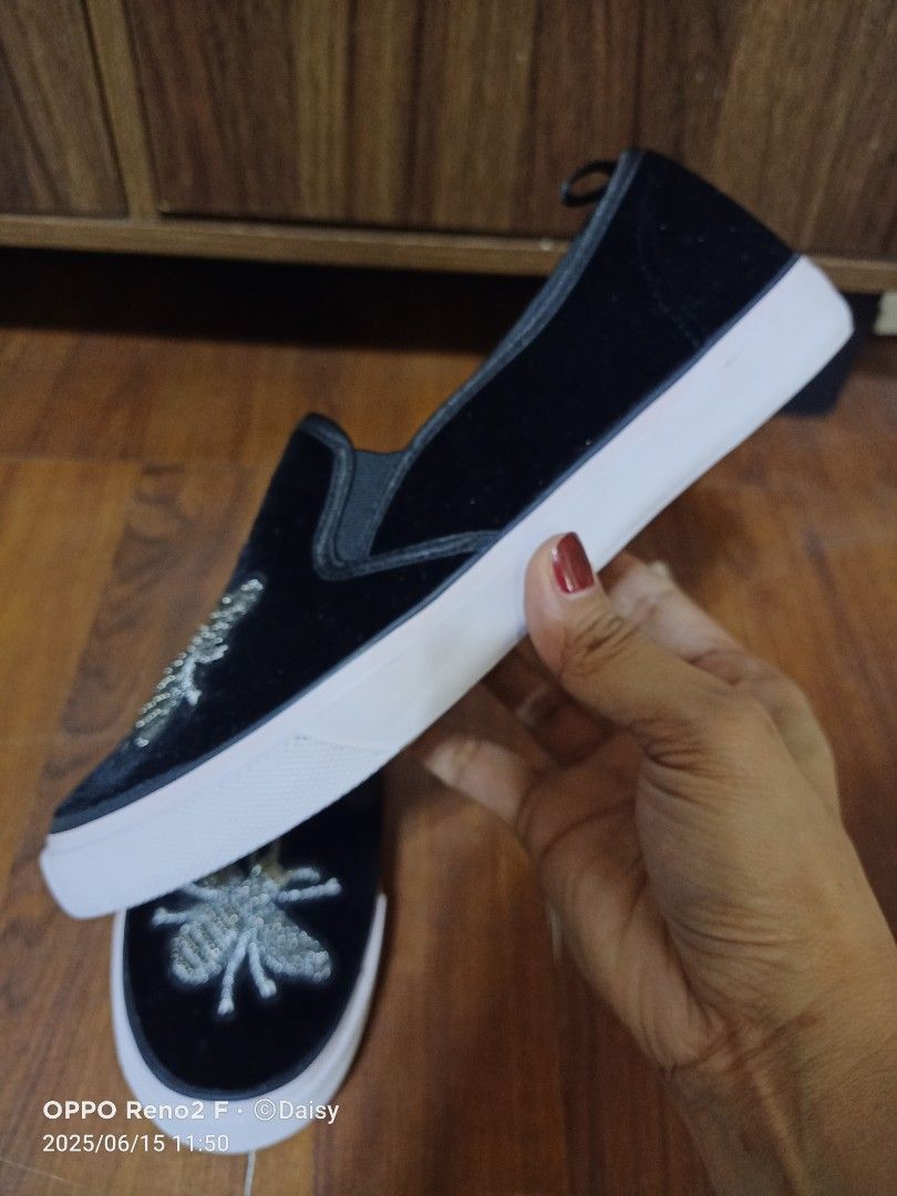 Primark Bee Embellished Slip-on Shoes (Category: Sneakers) located in Quezon City. Submitted by uydaisy1979 (Listing ID 1424758415, Image 3). Description: Black slip-on shoes from Primark. Features a bee embroidery on the front. The shoes have a white sole..