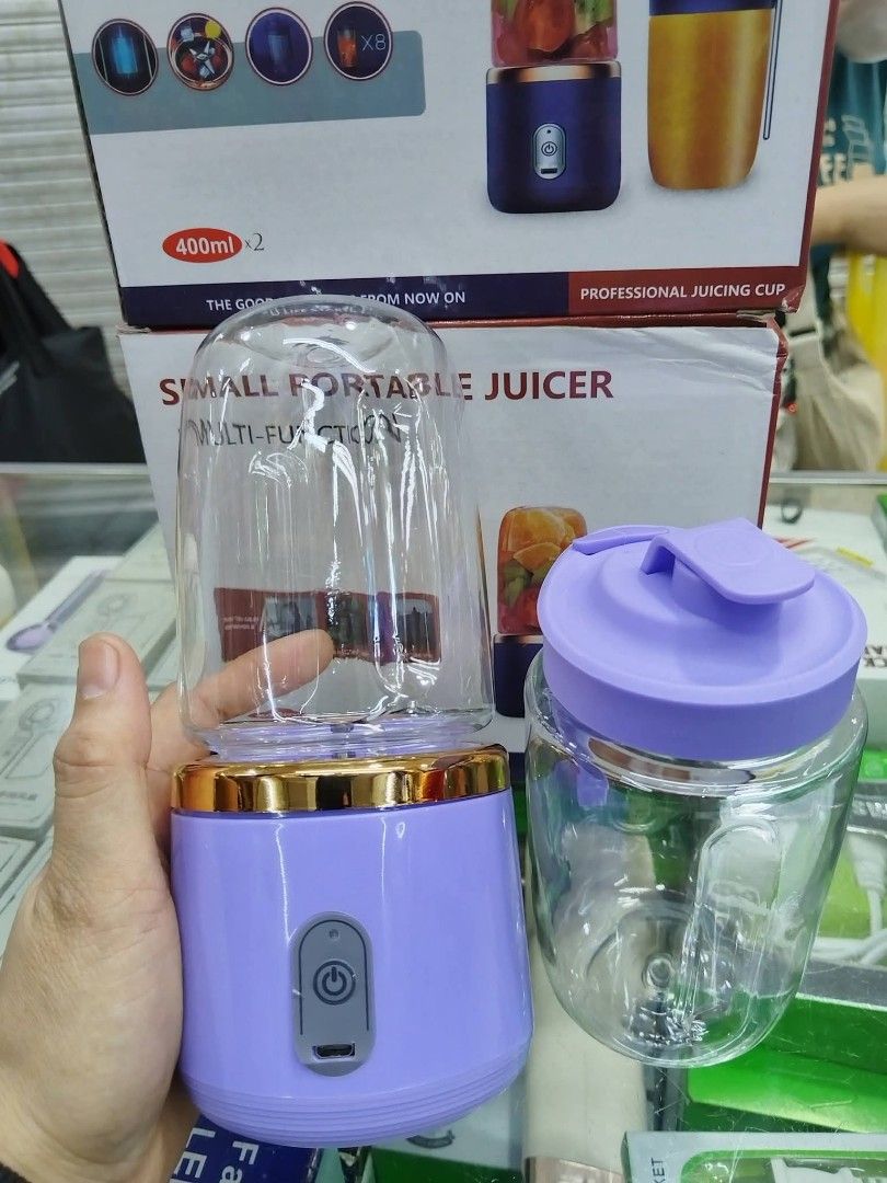 Small Portable Multi-Function Juicer (Category: Juicers, Blenders & Grinders) located in Manila. Submitted by haideshop (Listing ID 1424877092, Image 2). Description: Small portable juicer is multi-functional. It comes with a 400ml capacity cup and a separate container. The juicer has a purple base with a gold trim. It includes a lid for the cup. The images show how to cut ingredients, add water or milk, and use the start button. It is designed f