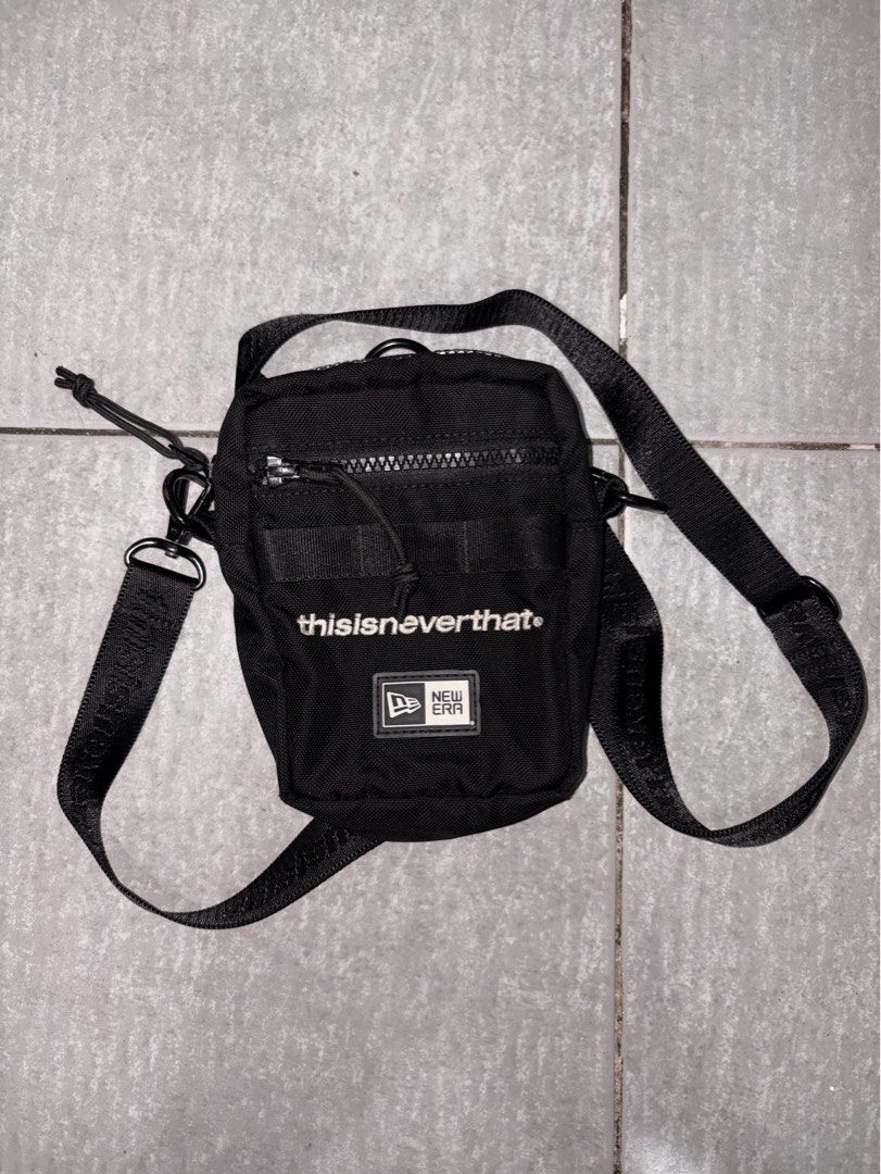 thisisneverthat x New Era Crossbody Bag (Category: Sling Bags) located in Mandaluyong City. Submitted by de_keein (Listing ID 1424868856, Image 1). Description: Black crossbody bag from thisisneverthat in collaboration with New Era. Features a main zippered compartment and an exterior pocket. Includes an adjustable strap with the thisisneverthat logo. The bag has a small New Era logo patch on the front. The interior tag provides additional detail