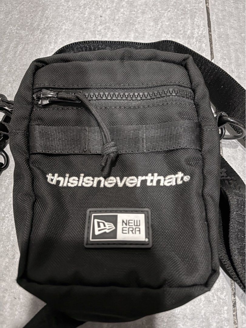 thisisneverthat x New Era Crossbody Bag (Category: Sling Bags) located in Mandaluyong City. Submitted by de_keein (Listing ID 1424868856, Image 2). Description: Black crossbody bag from thisisneverthat in collaboration with New Era. Features a main zippered compartment and an exterior pocket. Includes an adjustable strap with the thisisneverthat logo. The bag has a small New Era logo patch on the front. The interior tag provides additional detail