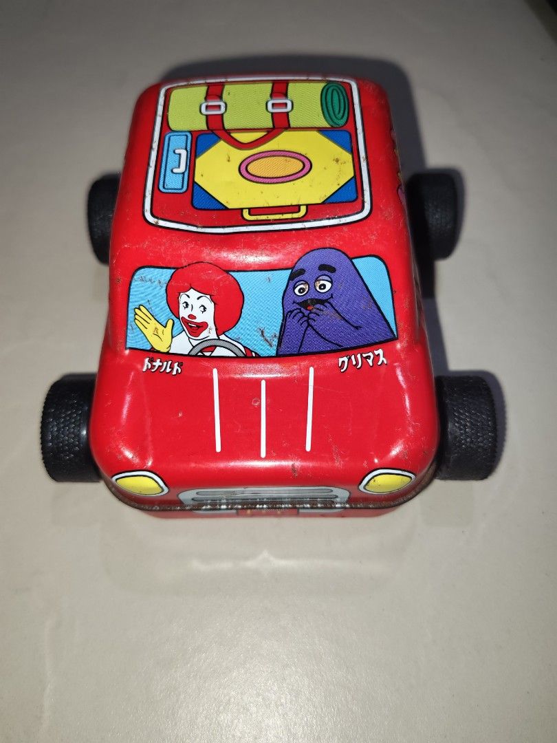 Vintage McDonald's Toy Car (Category: Vehicle & Diecast Models) located in Taguig. Submitted by tresfilijapanuksurplus (Listing ID 1424826792, Image 1). Description: - Vintage McDonald's toy car - Features Ronald McDonald, Grimace, and other characters - Red color - Metal construction - Black wheels - Luggage design on roof.