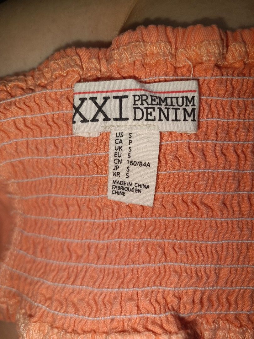 XXI Premium Denim Crop Top (Category: Others Tops) located in Quezon City. Submitted by Think_Like_Chinita (Listing ID 1424773664, Image 3). Description: Crop top features a peach color and adjustable straps. It has a smocked back and a zipper closure. The tag indicates it is a size S. Made in China..