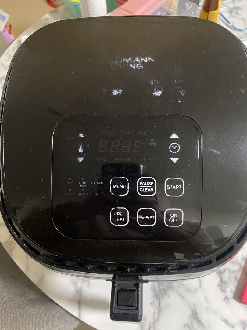 Baumann Living Air Fryer (Category: Fryers) located in Makati City. Submitted by rye16 (Listing ID 1425048451, Image 2). Description: Baumann Living air fryer with digital controls. Features include menu, pause/clear, start, pre-heat, reheat, and on/off buttons. The control panel displays temperature and time. It has a black exterior with a handle for easy carrying..