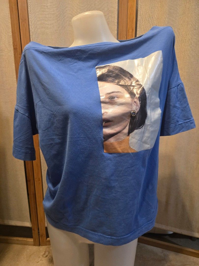 Blue Graphic Print T-shirt (Category: Tshirts & Polo Shirts ) located in Pasig City. Submitted by leildyne (Listing ID 1424980667, Image 1). Description: Blue t-shirt features a graphic print on the front. The shirt has short sleeves. The shirt is displayed on a mannequin..