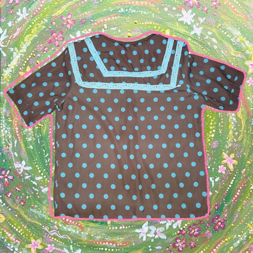 Brown Polka Dot Blouse with Blue Accents (Category: Blouses) located in Caloocan City. Submitted by faesrie (Listing ID 1424982286, Image 2). Description: Blouse features a brown base with blue polka dots. It has a V-neckline and short sleeves. The collar and sleeve edges are trimmed with blue accents. It has a button-down front closure..