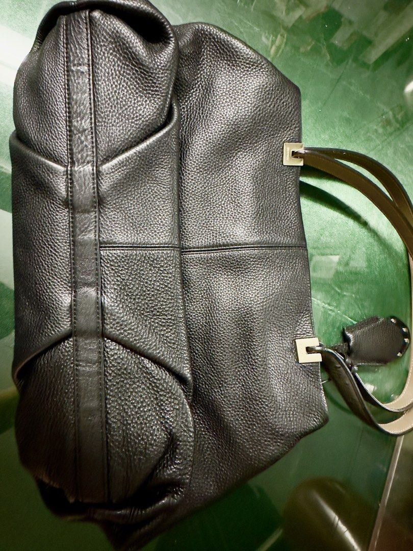 Bruno Magli Black Leather Tote Bag (Category: Luxury Bags & Wallets) located in Angeles City. Submitted by ritenianstuff (Listing ID 1424973727, Image 2). Description: Genuine leatherblack tote bag by Brunomagli. Features a spacious interior with multiple compartments and a zip closure. Includes a detachable leather tag with the brand's logo. The bag has double handles with a unique design. The interior lining has a branded pattern. Gold hardware