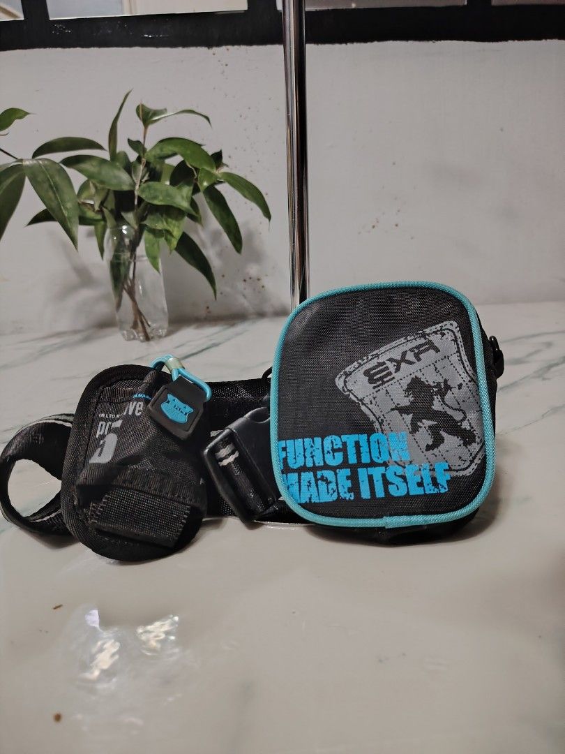 EXR Function Made Itself Bag (Category: Luxury Bags & Wallets) located in Manila. Submitted by drxx.drip_19 (Listing ID 1425034880, Image 1). Description: EXR bag features a black and teal design. It has a small, square pouch with the words "FUNCTION MADE ITSELF" printed on it. The bag has a zipper closure and a small loop. The bag also has a strap..