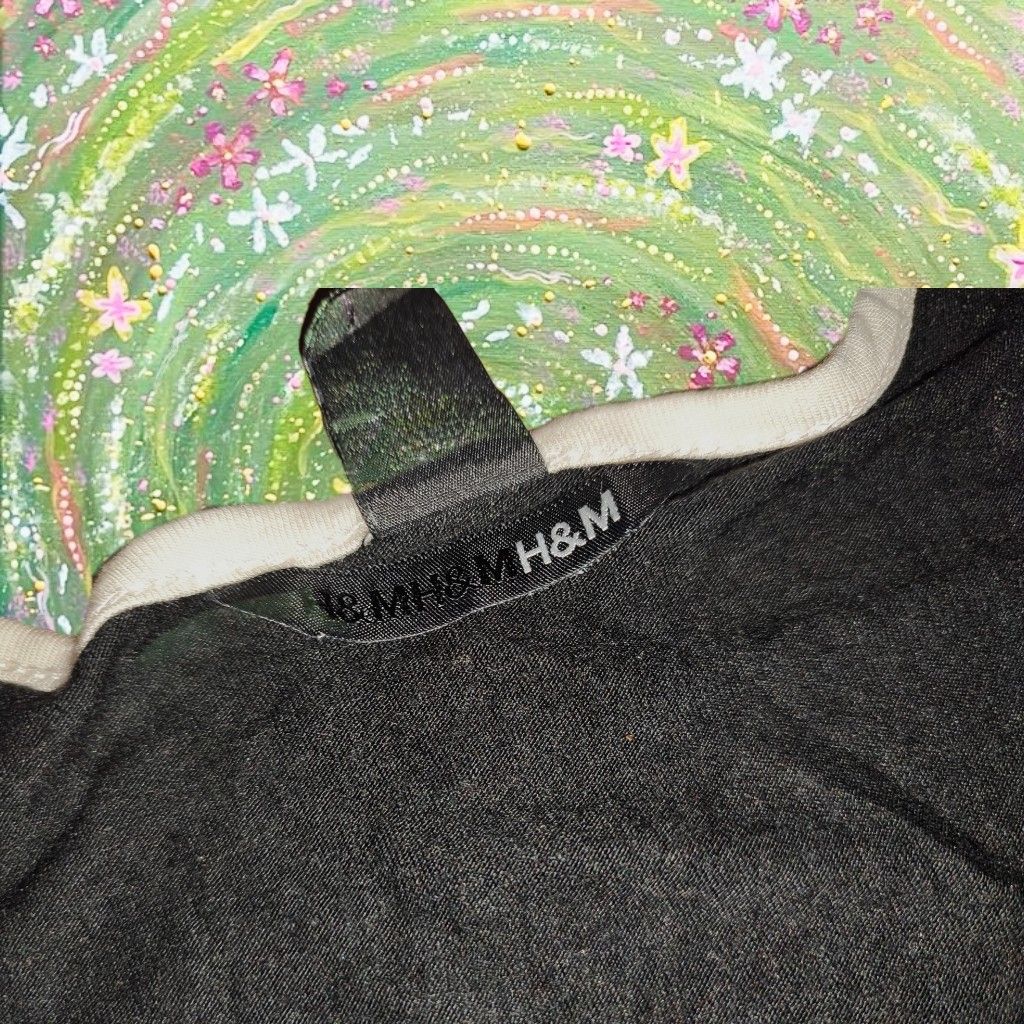H&M Black Top with White Details (Category: Sleeveless) located in Caloocan City. Submitted by faesrie (Listing ID 1424982194, Image 2). Description: H&M top features a black body with white trim and accents. It has a sleeveless design with decorative ruffles on the shoulders. The top includes a white band at the waist. The neckline is also trimmed in white..