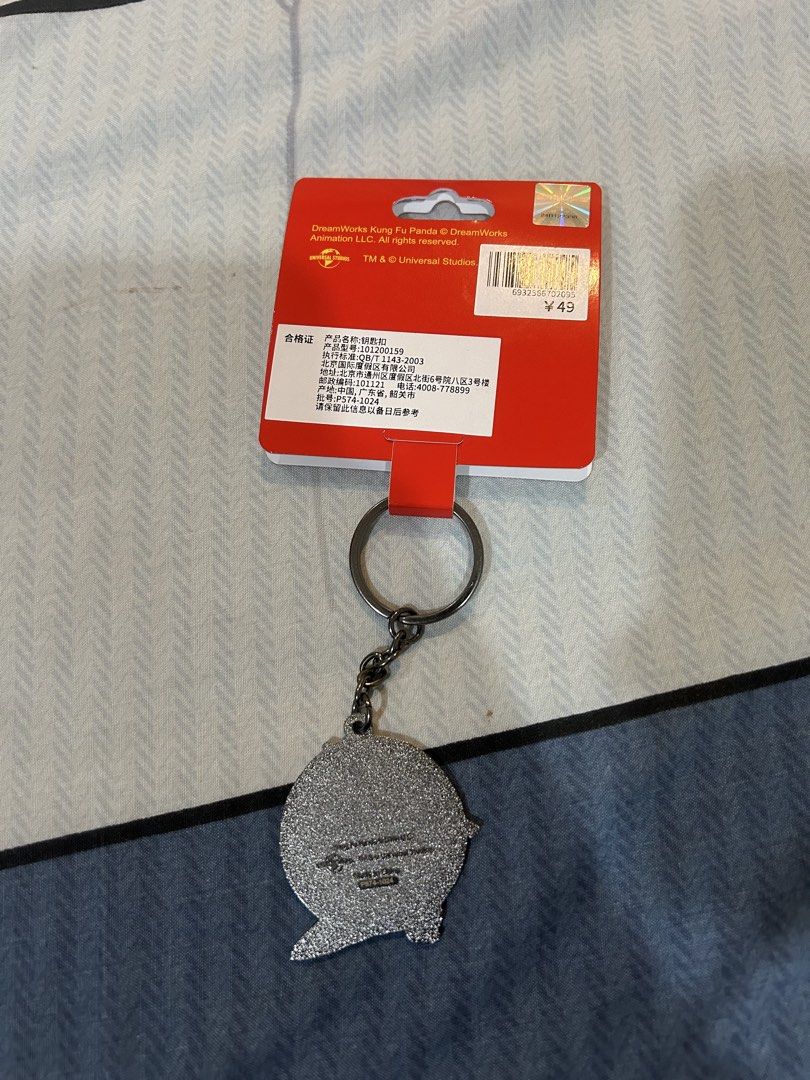 Kung Fu Panda Keychain (Category: Character Goods) located in Manila. Submitted by alainachu (Listing ID 1425028244, Image 2). Description: Brought from Universal Studios Beijing Keychain features a design of Po from Kung Fu Panda. It has a red background with Po in a fighting stance. The keychain is attached to a metal chain and a keyring. The tag shows the Universal Studios logo. Loc: San Juan City.