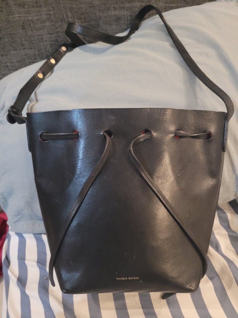 Mansur Gavriel Drawstring Shoulder Bag (Category: Luxury Bags & Wallets) located in Valenzuela. Submitted by flzoneeee (Listing ID 1424912387, Image 1). Description: Black Mansur Gavriel drawstring shoulder bag. Features a single shoulder strap with adjustable length. The bag has a drawstring closure and a small logo on the side. The bag has a simple, minimalist design..