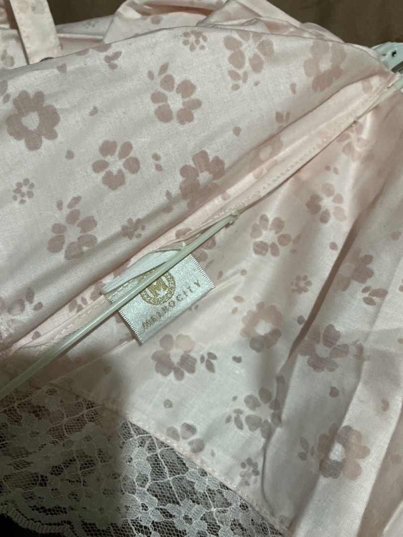 Metrocity Floral Lace Umbrella (Category: Umbrellas) located in Angeles City. Submitted by goodbuysathome (Listing ID 1425023027, Image 2). Description: Elegant Metrocity umbrella featuring a delicate floral pattern and lace trim. The umbrella is light pink with a clear handle and gold accents. It has a strap with the Metrocity logo. When open, the umbrella measures approximately 45cm in length. When closed, it measures approximately 25cm in leng