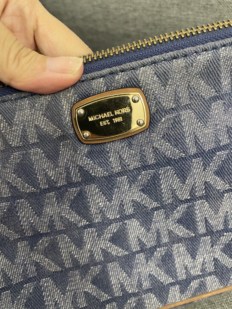 Michael Kors Denim Kili bag (Category: Luxury Bags & Wallets) located in Makati City. Submitted by chinyher (Listing ID 1425033332, Image 2). Description: Authentic Michael Kors handbag in denim material. Features a top handle and a detachable strap. The bag has a gold-tone zipper and hardware. The interior includes multiple compartments and the Michael Kors logo. The exterior displays the MK logo pattern. Includes a small gold-tone plaque with t
