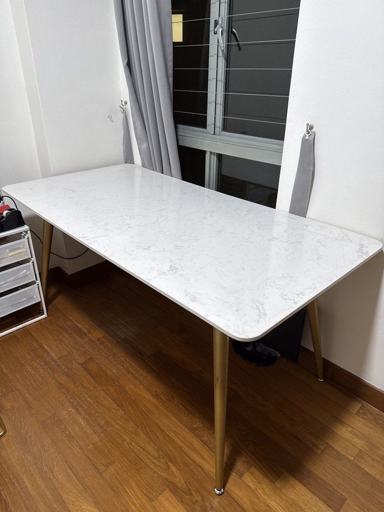 Dining Table (Category: Tables & Sets) located in Singapore. Submitted by greenlifetime (Listing ID 1405947341, Image 1). Description: - White marble-look dining table with gold legs - Suitable for small to medium dining areas Dimension: 160cm x 80cm x 75cm Size good for 4-6 pax Listing is for dining table. Been with me for over 1 year. In good condition. Welcome to view actual item prior to purchase Family has no pets and non-smoking household. 